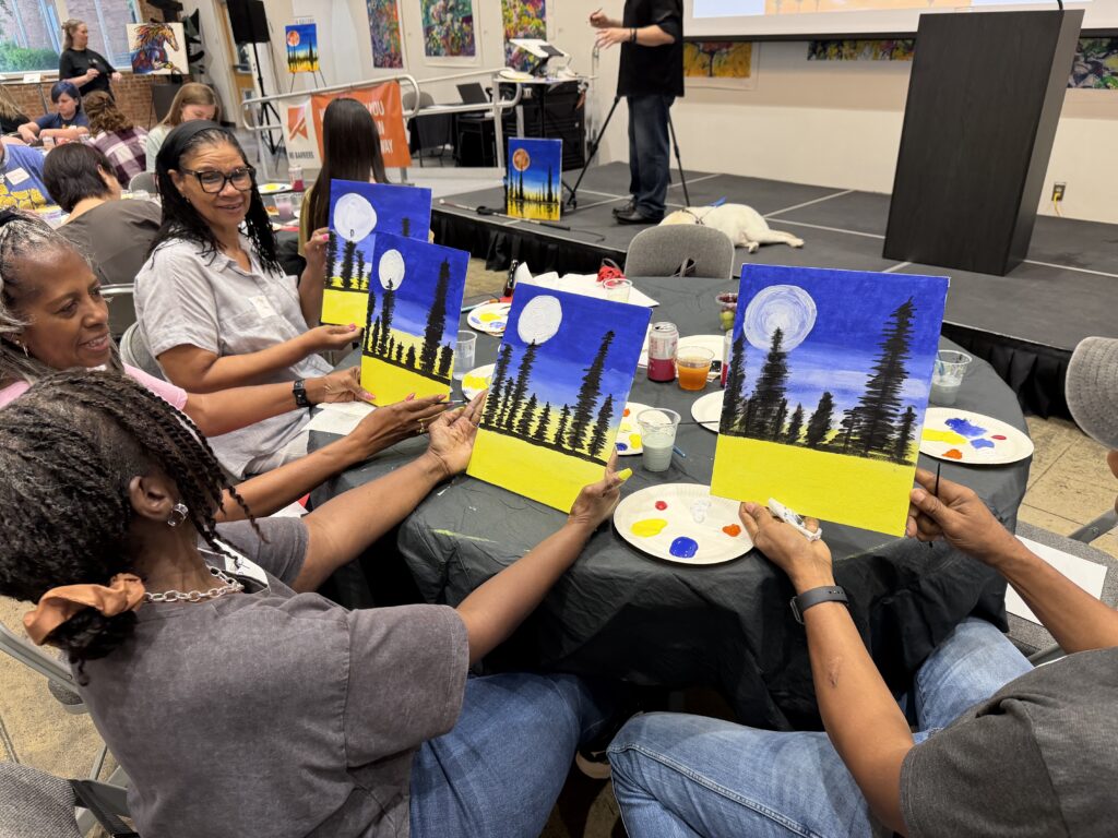 A group paints tree-lined landscapes together.
